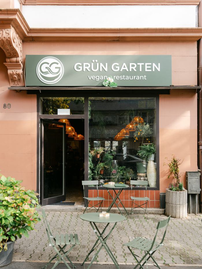 Eingang von Grün Garten mit grünem Schild und Pflanzen vor dem Fenster